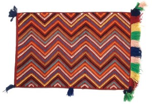 Commercially produced yarn colored brightly using aniline dyes enabled Navajo weavers to create what traders called Eye-Dazzlers. This example (53 by 35 inches), having long looped fringe on the lower edge and sides, was from the Roy Rogers estate. It sold for $4,312.50, more than double the high estimate. Cowan’s Auctions.