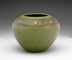 A rare and exceptional Marblehead vase incised and painted with stylized brown and yellow blossoms on a polychrome band, against an olive green ground. Glazed-over firing line to bottom. Ship stamp and paper label.  6 inches by 7 1/2 inches. Estimate $5,000-$8,000. Image courtesy Rago.