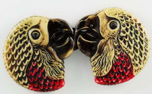 These celluloid parrot heads are a two-piece belt buckle. Image courtesy of Bella Button Auctions.