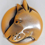 A big dog's head was carved into this celluloid button. Image courtesy of Bella Button Auctions.