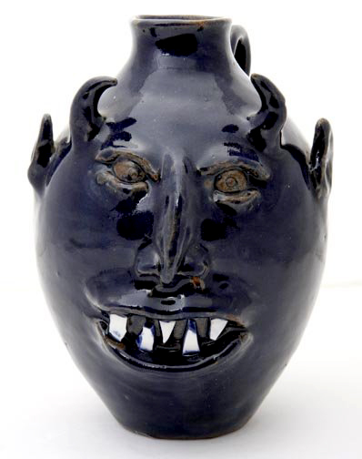 Blind potter Roger Hicks signed this blue face jug, which is 9 inch high by 7 inches wide. It has a $200-$300 estimate. Image courtesy Kimball M. Sterling Inc.