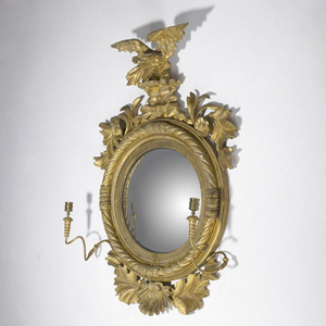 An eagle stands atop a late-18th-century English mirror having a convex glass and two candleholders. Measuring 36 by 25 inches, the mirror has a $2,500-$3,500 estimate. Image Courtesy Rago Arts and Auction Center.