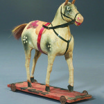 Antique papier-mache and wood horse with tiny spoke-metal wheels. Image courtesy Clarity Sells.