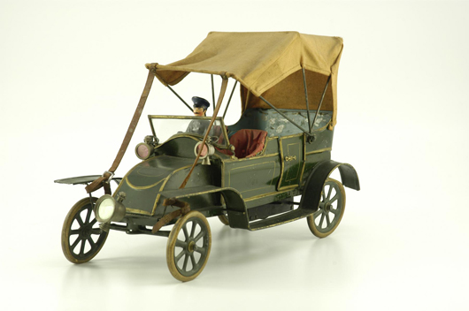 Circa-1905 Torpedo clockwork car attributed to French manufacturer Pinard. Hand-painted tin, folding canvas top, plush canvas-lined seats with button-tufted look, solo headlamp. Estimate $6,000-$8,000.
