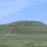 Monk's Mound, a Pre-Columbian Mississippian culture earthwork, located at the Cahokia site near Collinsville, Illinois. The concrete staircase is modern, but it is built along the approximate course of the original wooden stairs. Image courtesy Wikimedia Commons.