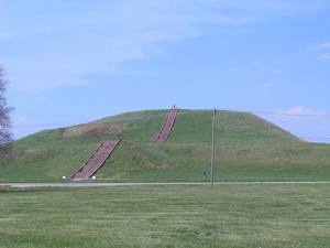 Monk's Mound, a Pre-Columbian Mississippian culture earthwork, located at the Cahokia site near Collinsville, Illinois. The concrete staircase is modern, but it is built along the approximate course of the original wooden stairs. Image courtesy Wikimedia Commons.