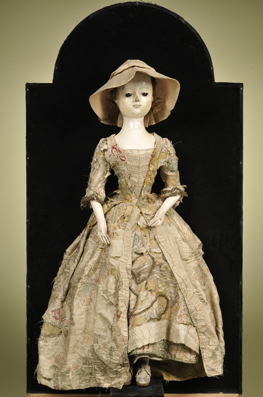Circa-1720 Queen Anne lady doll, England, 25 inches tall, gessoed and painted carved-wood head, wood torso with mortise and tenon jointed wood arms and legs. Presented in mahogany and walnut veneered display case. Estimate $50,000-$70,000. Image courtesy Skinner Inc.