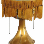This is more than a lamp. Hiding under the fringed lampshade is a disc phonograph. This vintage table lamp sold for $1,200 at Morphy Auctions in Denver, Pa.