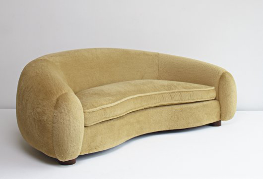 Jean Royere's ‘Ours Polaire' sofa circa 1951 is considered rare. Made of oak and fabric, the sofa is 94 inches long and has a $158,000-$238,000 estimate. Image courtesy of Phillips de Pury & Co.