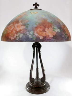 The 18-inch reverse-painted shade on this table lamp is signed 'Handel 6688 NI' (artist's initials). The lamp has a $10,000-$15,000 estimate. Image courtesy DuMouchelles.