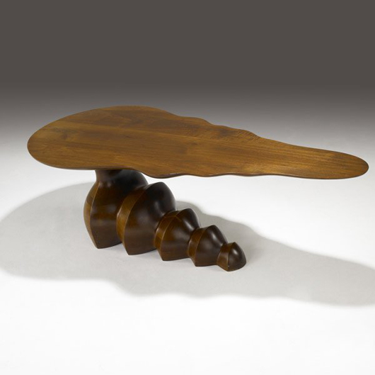 An unusual cantilevered corkscrew base steadies Wendell Castle's 1980 walnut coffee table. The top is 53 inches long. The estimate is $40,000-$60,000. Image courtesy of Sollo Rago Modern Auctions.