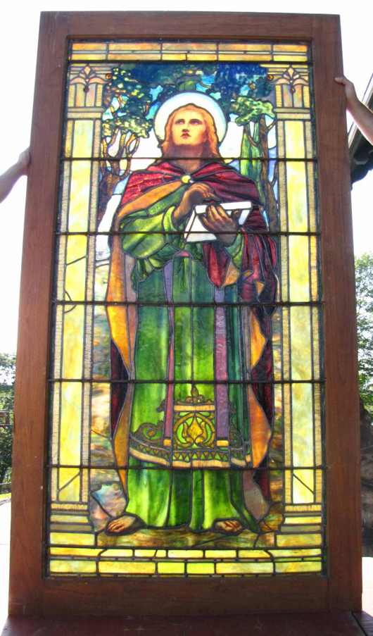 The quality and design of this leaded stained glass match that of Tiffany Studios, which is signed on the bottom right. The window measures 84 inches by 40 inches and has a $90,000-$150,000 estimate. Image courtesy of Bob Courtney Auctions.