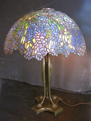 Laburnum leaded glass shades by Tiffany are rarely found in blue. On its cat’s paw base, this table lamp stands 30 inches high. The estimate is $60,000-$90,000. Image courtesy of Bob Courtney Auctions.