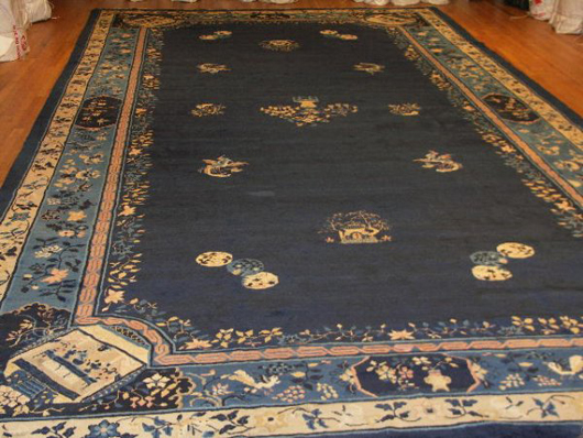 This large Chinese rug has an Art Deco design on blue. It has a $16,000-$24,000 estimate. Image courtesy of Antique Carpets Online.