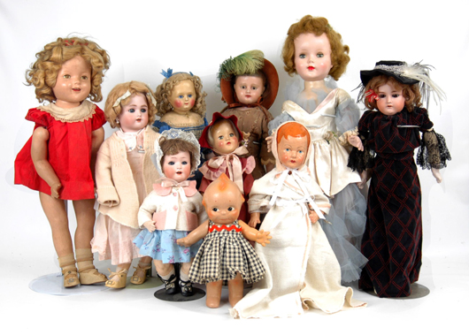 Grouping of dolls including examples made of wax, bisque and other materials. At far left is a Shirley Temple doll, and at front and center is a Kewpie. Image courtesy of Stephenson’s Auctioneers & Appraisers.