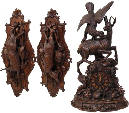 A collection of Black Forest carved pieces include a pair of large trophy plaques and a fine cuckoo shelf clock. Image courtesy of Austin Auction Gallery.