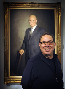 Retiring curator Dennis Medina stands by a portrait of President Dwight D. Eisenhower. Photo by Tom Dorsey, Salina Journal.