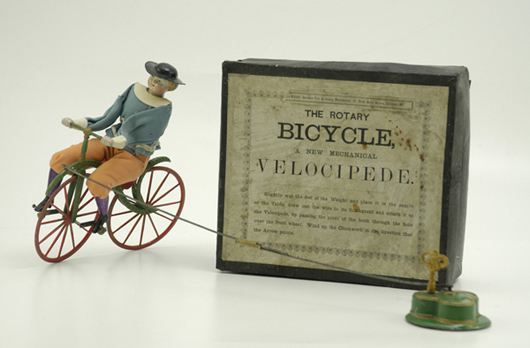 Circa-1880s Britains boxed clockwork velocipede, hand-painted lead with cloth attire, possibly only known example, $23,000. Bertoia Auctions image.