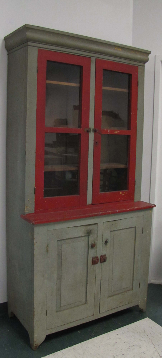 This 19th-century step-back cupboard is a Shaker piece. It is painted butternut, 84 inches high by 43 inches wide. The estimate is $6,000-$10,000. Image courtesy of William J. Jenack Auction Gallery.