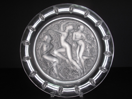 A fine Lalique Cote d’Or charger of clear and frosted glass, decorated with three nude nymphs known as Trois Figurines et Raisins, sold to an Internet bidder for $1,782.50.