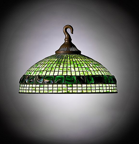 Marked ‘Tiffany Studios, New York,’ this four-light chandelier with green geometric leaded glass panels and a wide band of turtleback tiles has fiery iridescence. It carries a $25,000-$35,000 estimate. Image courtesy of Cowan’s Auctions.