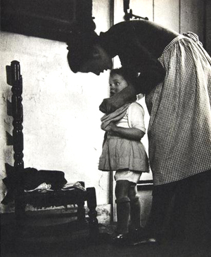 A photographic image from the book ‘Mother and Child’ shows Tasha Tudor dressing a youngster. Image courtesy Bloomsbury and Live Auctioneers Archive.