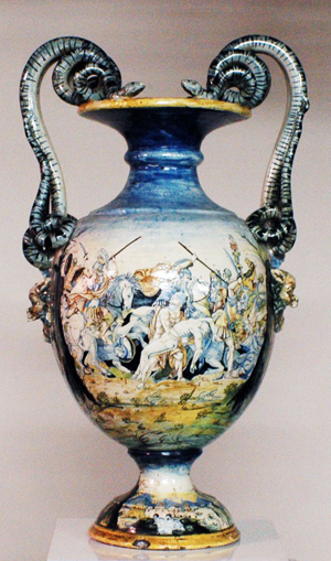 Colorfully painted allegorical scenes enhance this glazed majolica urn, which was made in Italy during the 18th or 19th century. With chips to the base and restoration to the handles, the 31-inch-tall urn has a $3,500-$4,500 estimate. Image courtesy of Auction Gallery of the Palm Beaches Inc.