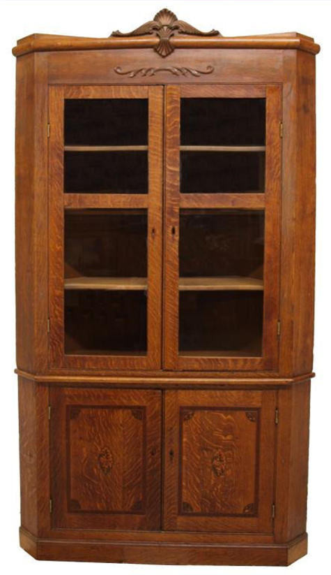 The marquetry doors on the bottom of this quarter-sawn oak corner cupboard have shell medallions and string work with each corner inlaid with foliates and acorns. It is 93 inches high by 50 inches wide by 29 inches deep. It has an $800-$1,200 estimate. Image courtesy Austin Auction Gallery.