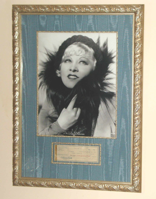 A personal check signed by Mae West accompanies a studio photo of the 1930s movie star, both in a gold-leaf frame. Image courtesy Gordon S. Converse & Co.