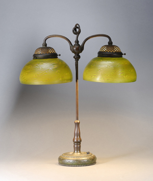 The base of this 26-inch-tall student lamp is marked ‘Tiffany Studios, New York, 318.’ With unmarked green damascene shades of iridescent art glass, the lamp is estimated at $8,000-12,000. Image courtesy Skinner Inc.