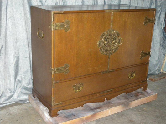 This Oriental teak buffet has five drawers, one of which is felt lined for flatware. It features ornate brass hardware including butterfly pulls. Image courtesy the Specialists of the South Inc.