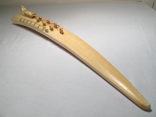 Ivory tusk carving of Alaskan Eskimo, sled and dog team, 23½ inches long, 3 inches high. Estimate $500-$800. Auctions Neapolitan image.