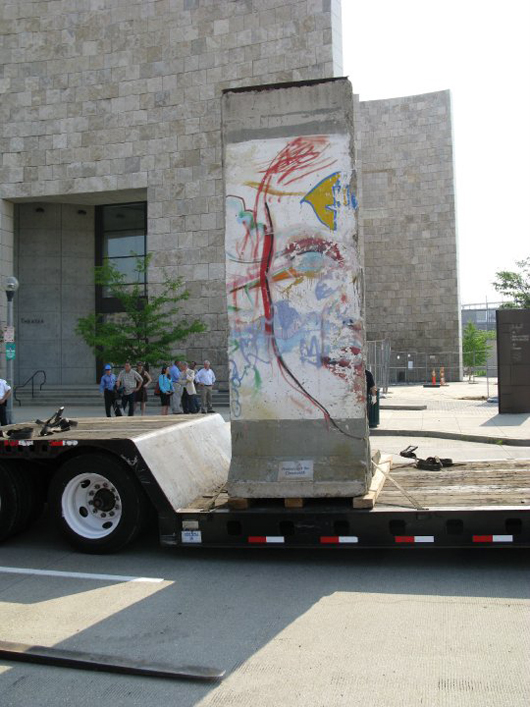 A section of the Berlin Wall, measuring 12 ft by 4ft and weighing two tons, arrives at the NURFC on a flatbed tractor-trailer truck. Image courtesy NURFC.