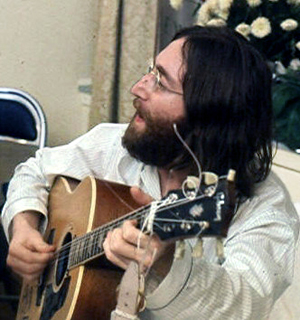 Genuine photo of John Lennon rehearsing Give Peace a Chance, 1969. Photo by Roy Kerwood, used by permission of the artist through Creative Commons Attribution 2.5 Generic license.