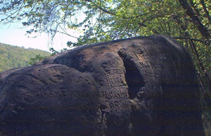 Many rocks bearing Native American petroglyphs have been discovered in Pennsylvania. Indian God Rock, a petroglyph-covered boulder along the Allegheny River in Rockland Township, Venango County, Pennsylvania, is listed on the National Register of Historic Places for the archaeological importance of its petroglyphs. Photo taken in May 2002 by Melissa N. Hayes-Gehrke. This file is licensed under the Creative Commons Attribution 3.0 Unported license.