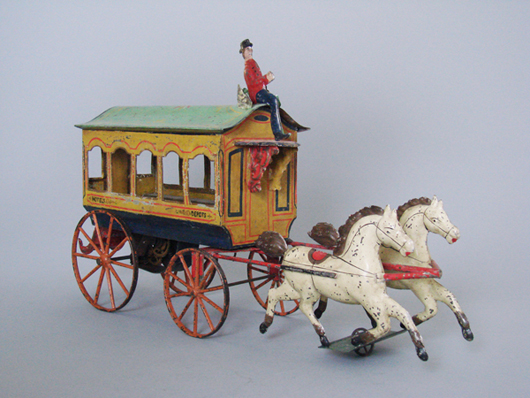 Circa-1865 American clockwork omnibus, painted tin with cast-iron wheels, probably Hull & Stafford, $47,385. RSL Auction image.