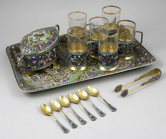 Set of Russian enameled serving pieces including six cups, six teaspoons, ice tongs, a covered box and a serving tray. Est. $5,000-$8,000). Image courtesy of Kaminski Auctions.