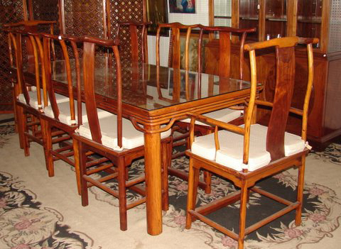 Glass-top Huanghuali table, 86 inches long, with eight round-leg chairs, two with arms: $10,800. Image courtesy of Finney’s Auction Service.
