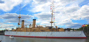 The 344-foot-long USS Olympia dwarfs a pleasure craft on the Delaware River in Philadelphia. Image courtesy of Wikimedia commons