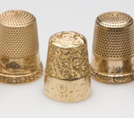 Approximately 100 gold thimbles will be sold in multiple lots. The thimble on the left is by Simons Brothers and features five engraved stars, each containing a pearl-like stone. Image courtesy of Jeffrey S. Evans & Associates.
