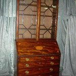 Two-piece, early 19th-century fall-front desk with bookcase top and inlaid conch in the drop. Image courtesy The Specialists of the South Inc.