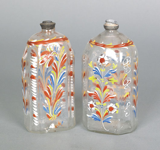 Two Stiegel-type glass enameled bottles, circa 1800, with floral decoration and pewter collars, 6 inches high, est. $300-$500. Image Pook & Pook Inc.
