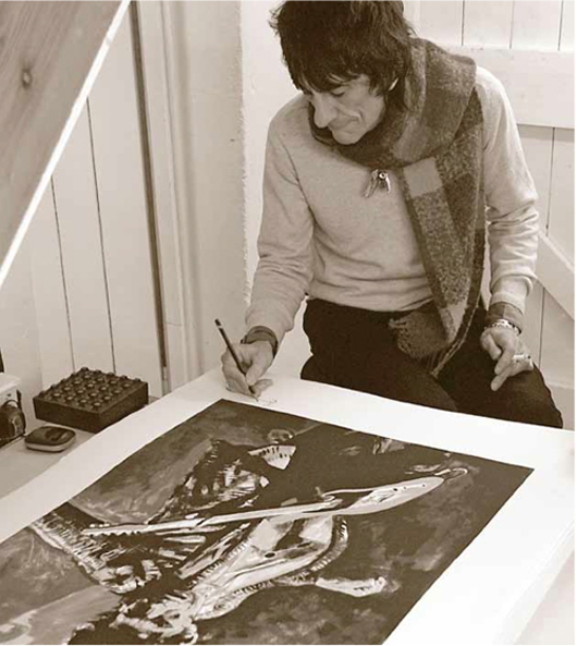 Ronnie Wood signs a completed painting. Image courtesy of the artist.