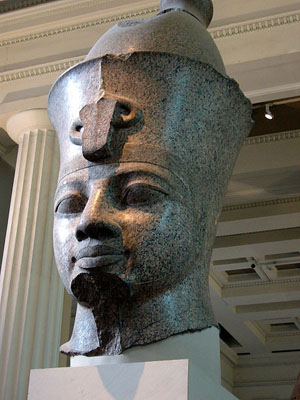 Red granite head of a pharaoh believed to be Amenhotep III, also known as Amenophis III. Housed in The British Museum, the head is from a giant statue in the Temple of Mut in Thebes (c. 1390 BC), one of a pair of statues that stood in front of the Temple of Khonspekhrod. The arm is also in the British Museum, but the torso remains at the original site. Licensed under the Creative Commons Attribution-Share Alike 3.0 Unported 2.5 Generic, 2.0 Generic and 2.0 Generic licenses.