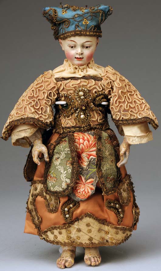 Fine circa-1750 fully jointed wood church figure of The Christ Child, probably Flemish, 12 inches tall, elaborate outfit of satin and brocade trimmed with gemstones, pearls and sequins. Blue ribbon winner at UFDC National Convention Exhibit. Estimate $4,000-$6,000. Morphy Auctions image.