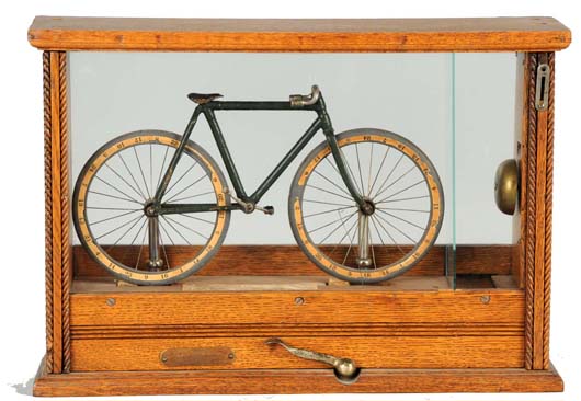 Circa-1900 coin-operated Coin-Operated “Waddle the Bicycle” trade stimulator, nickel-plated bicycle in oak case, estimate $6,000-$9,000. Morphy Auctions image.