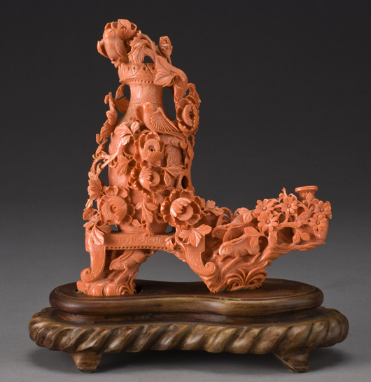 Chinese carved red coral vase depicting two vases and flowers, raised on a wood stand, with stand 11 inches high x 10 inches wide x 4 inches deep, circa early 20th century, price realized: $25,725. Image courtesy of Dallas Auction Gallery.