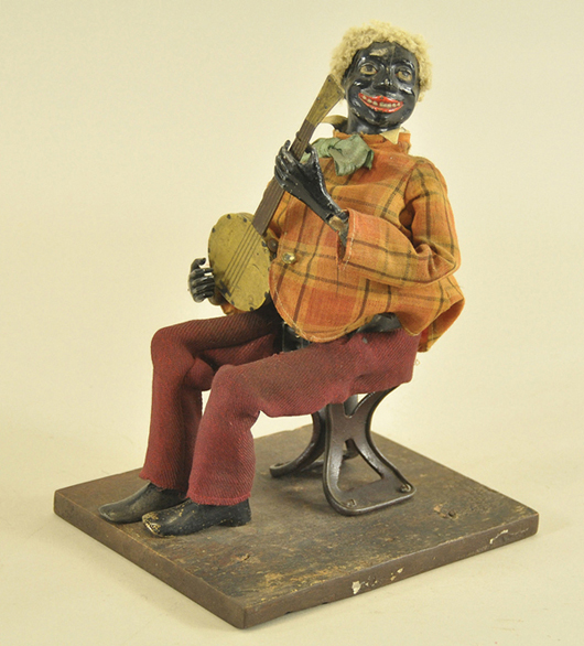 Made around 1870 this 11-inch Secor Banjo Player is constructed of cast iron and lead, and retains its original blond hair and fabric clothing. Estimate $22,500-$27,500. Bertoia Auctions image.