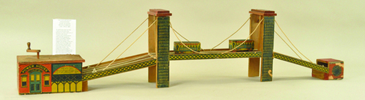 Possibly made by Reed, this exceedingly rare paper-on-wood Brooklyn Bridge with powerhouse, 48 inches long, has a hand crank that activates a rope-pull system to move two cars from end to end. Estimate $5,000-$6,500. Bertoia Auctions image.