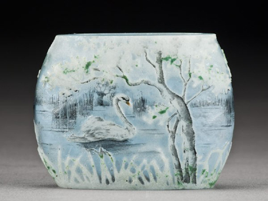Pillow form vase in mottled gray graduating to blue glass decorated with swan swimming by a tree covered shoreline, signed, ‘Daum Nancy,’ 1 1/2 inches high x 2 inches wide, $2,200. Image courtesy of Dallas Auction Gallery.